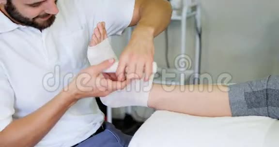 物理治疗师在受伤的病人脚上包扎视频的预览图