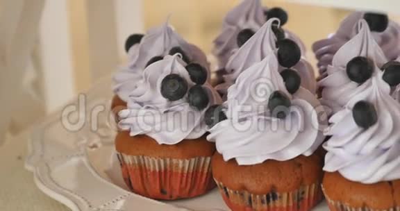 用奶油和新鲜浆果装饰的美味蓝莓纸杯蛋糕视频的预览图