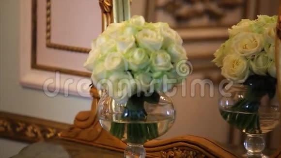玻璃花瓶里放着白色玫瑰和甘蓝康乃馨的花束视频的预览图