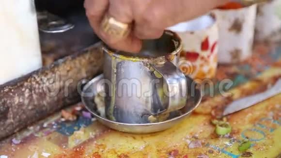 男人把生鸡蛋倒在杯子里然后在街摊上用叉子搅拌视频的预览图