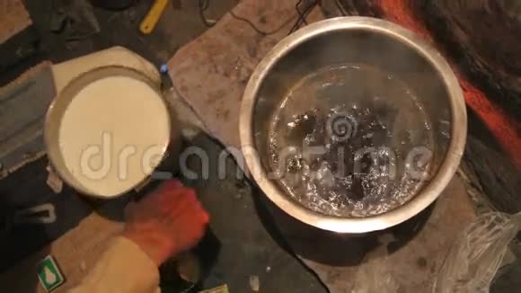 人将白色液体倒入锅中沸水视频的预览图