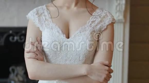 美丽活泼的黑发新娘穿着白色连衣裙摆在壁炉背景上视频的预览图