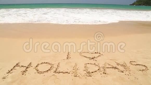 在海浪覆盖之前女孩走在沙滩上写着节日的文字前视频的预览图