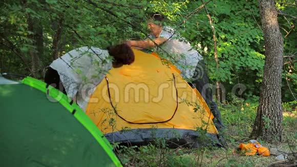 女孩和男人在落叶中搭帐篷视频的预览图