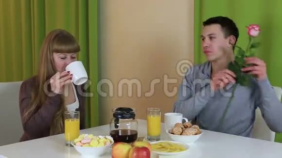 年轻人给他女朋友惊喜他给她一朵玫瑰作为早餐视频的预览图