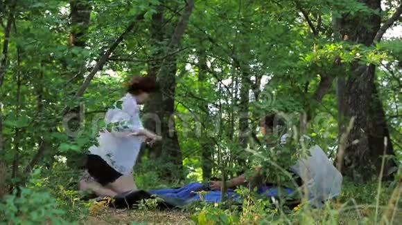 女孩和男人在落叶中搭帐篷视频的预览图