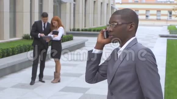一群快乐的多种族商人打电话的非裔美国人视频的预览图