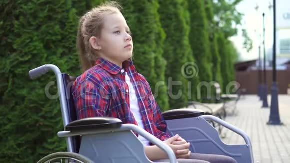 女孩是残疾人坐在轮椅上是悲伤的一个视频的预览图