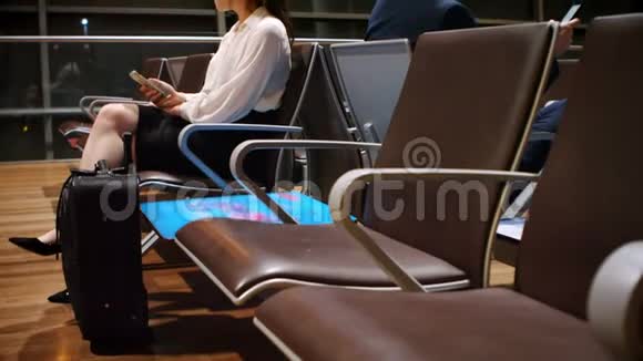 乘客在等候区使用手机4k视频的预览图