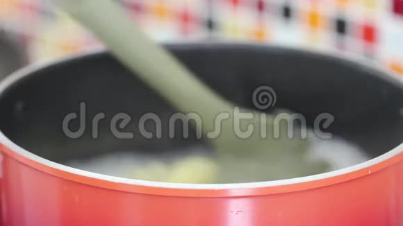 在煮沸的锅中搅拌通心粉并展示成熟的通心粉视频的预览图