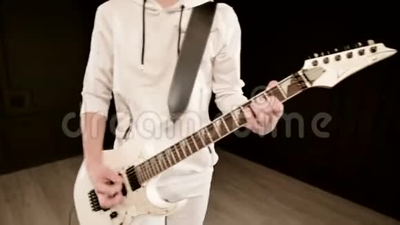时尚的节奏吉他手不同的眼睛穿着白色的衣服在黑色的背景富有表现力地演奏白色视频的预览图
