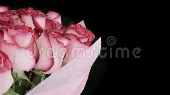 在深色背景上旋转顺时针粉红色玫瑰花蕾视频的预览图