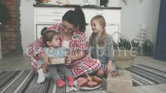 漂亮的年轻妈妈和她可爱的小女儿在厨房里烤饼干切割器微笑视频的预览图