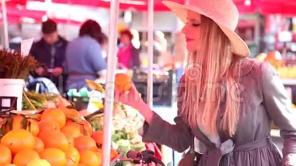 金发女孩骑着自行车在市场上闻着水果视频的预览图