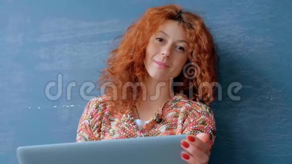 一个红头发的女人在笔记本电脑上工作的肖像视频的预览图