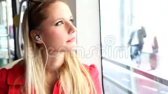 年轻漂亮的金发女郎坐电车听音乐跳舞视频的预览图