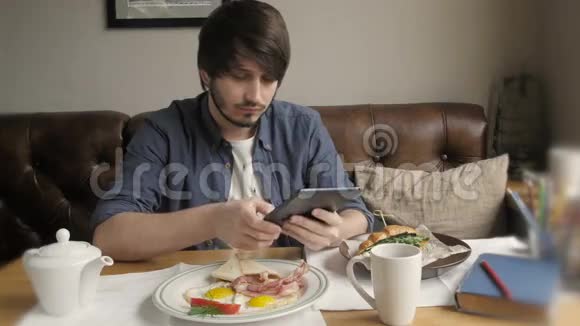 使用数码平板电脑吃健康早餐的嬉皮士视频的预览图