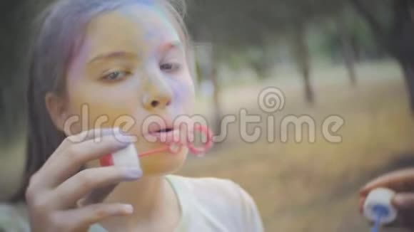 两个女孩弄脏了干燥的颜色霍利笑和吹泡泡视频的预览图
