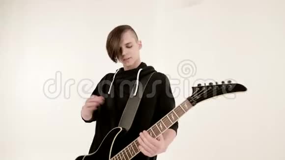 时尚的节奏吉他手不同的眼睛穿着黑色的衣服在白色的背景上演奏黑色视频的预览图