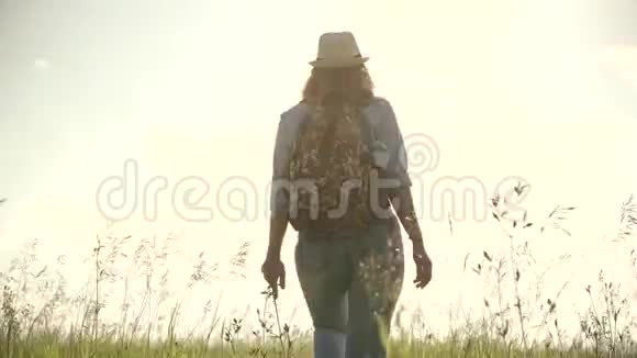 年轻的女游客去草地上戴着太阳镜帽子和背包的女旅行者视频的预览图