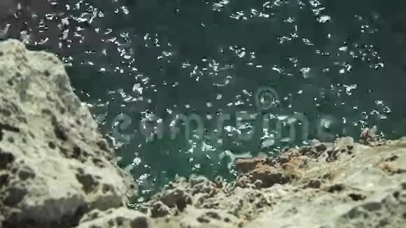 海湾沿岸的老岩石被风和石头的波浪所模糊视频的预览图