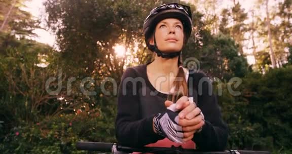 站着骑自行车的女登山运动员抬头看视频的预览图