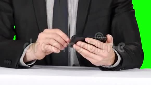 商人坐在桌边用电话特写镜头绿色屏幕视频的预览图