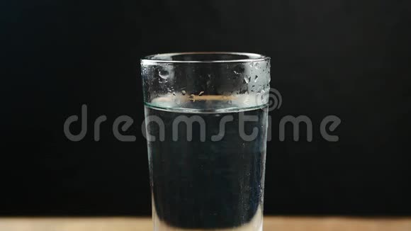 在水中加入泡腾片的玻璃杯关于黑色视频的预览图