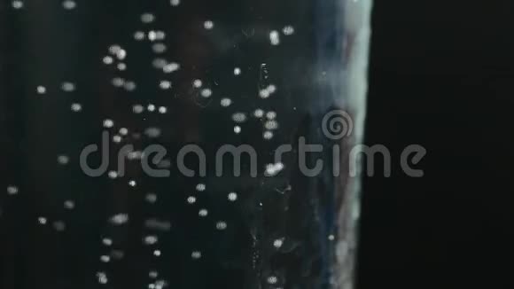 在水中加入泡腾片的玻璃杯关于黑色视频的预览图