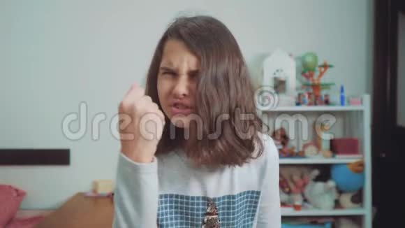 少女愤怒的手势拳头威胁慢动作视频女孩用拳头威胁少女要求视频的预览图