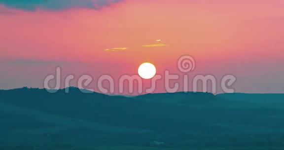 夕阳的背景下夕阳落在紫罗兰色的云后时光流逝温暖多彩的天空视频的预览图
