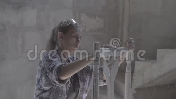 这个女孩在一个木工车间工作擦家具视频的预览图