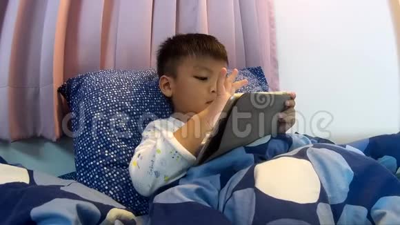 亚洲小孩在平板电脑上玩游戏视频的预览图