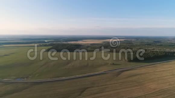 飞行上方的乡村绿地森林和村庄早春空中全景视频的预览图