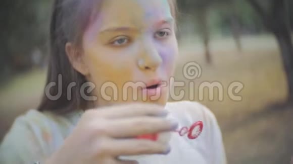 两个女孩被干颜色弄脏了霍利吹肥皂泡视频的预览图