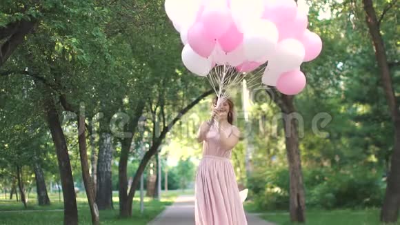 年轻迷人的女人手里拿着很多气球慢动作视频的预览图