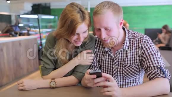 年轻夫妇上网看手机上的照片视频的预览图