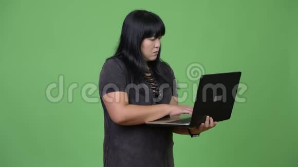 快乐超重的亚洲女人思考笔记本电脑视频的预览图