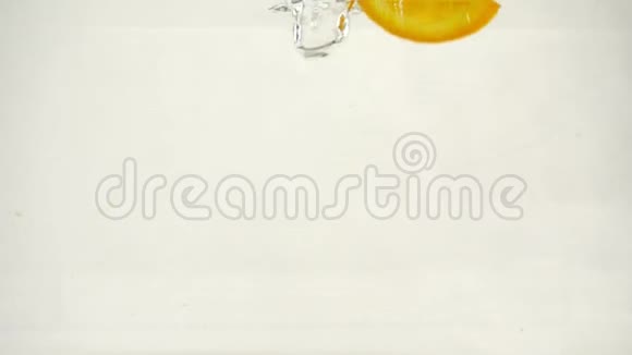 多汁的橙片落入水中溅起水花和气泡慢动作特写视频的预览图