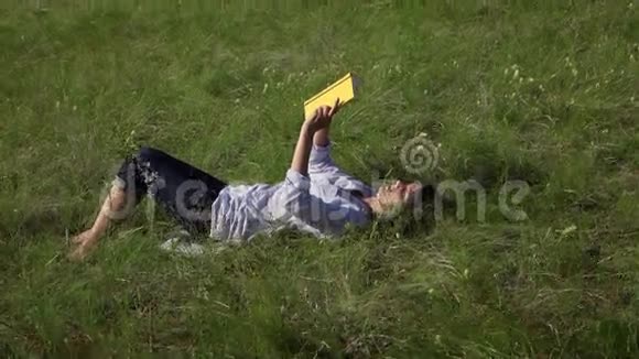 躺在绿色草坪上的女书视频的预览图