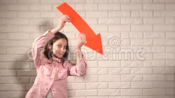 穿着粉色衬衫的少女在红色箭头上展示了一些东西视频的预览图