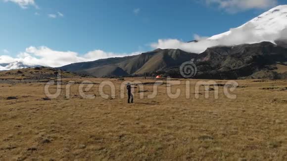 一位女摄影师在山上的高原上漫步镜头放在岩石和岩石的背景上视频的预览图