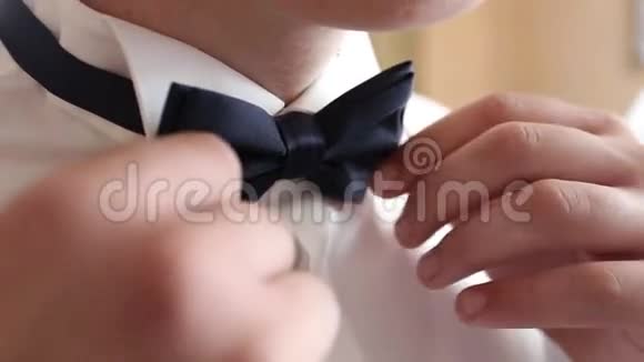 一位身穿黑色领带的绅士的特写使他的领结挺直视频的预览图