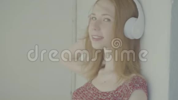 美丽的红发女人带着耳机听音乐彩色个人资料视频的预览图
