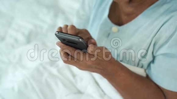在床上使用手机的老年妇女视频的预览图