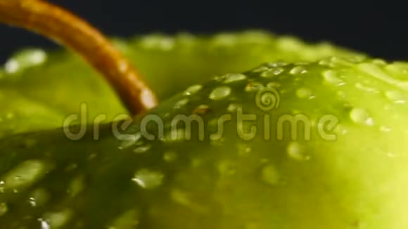 带水滴的绿苹果在黑色背景下旋转视频的预览图