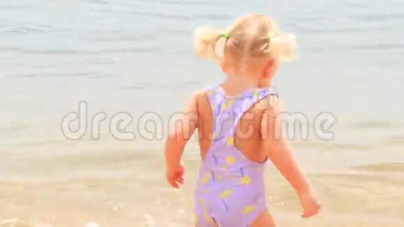 小女孩背着海甲在浅海中散步视频的预览图