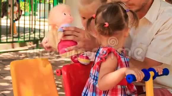 小女孩在秋千上玩石头其他女孩在公园里玩石头娃娃视频的预览图