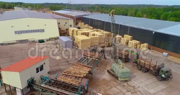 用起重机卸载原木车在锯木厂卸载原木在锯木厂从空中工作视频的预览图