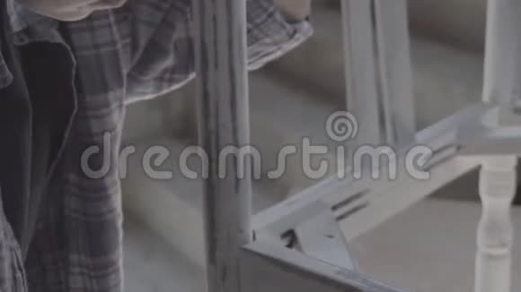 这个女孩在一个木工车间工作擦家具视频的预览图